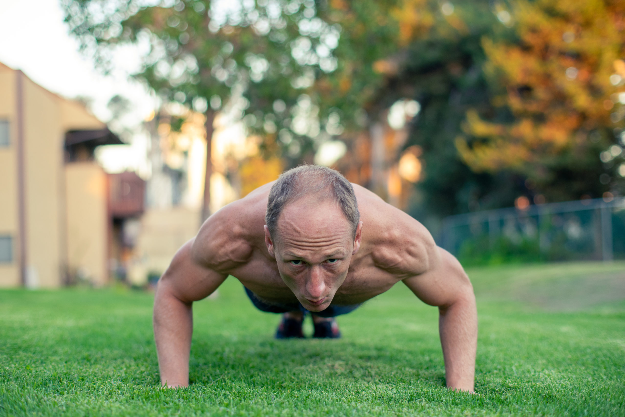 Busy dad performing a bodyweight burpee during a minimalist home workout